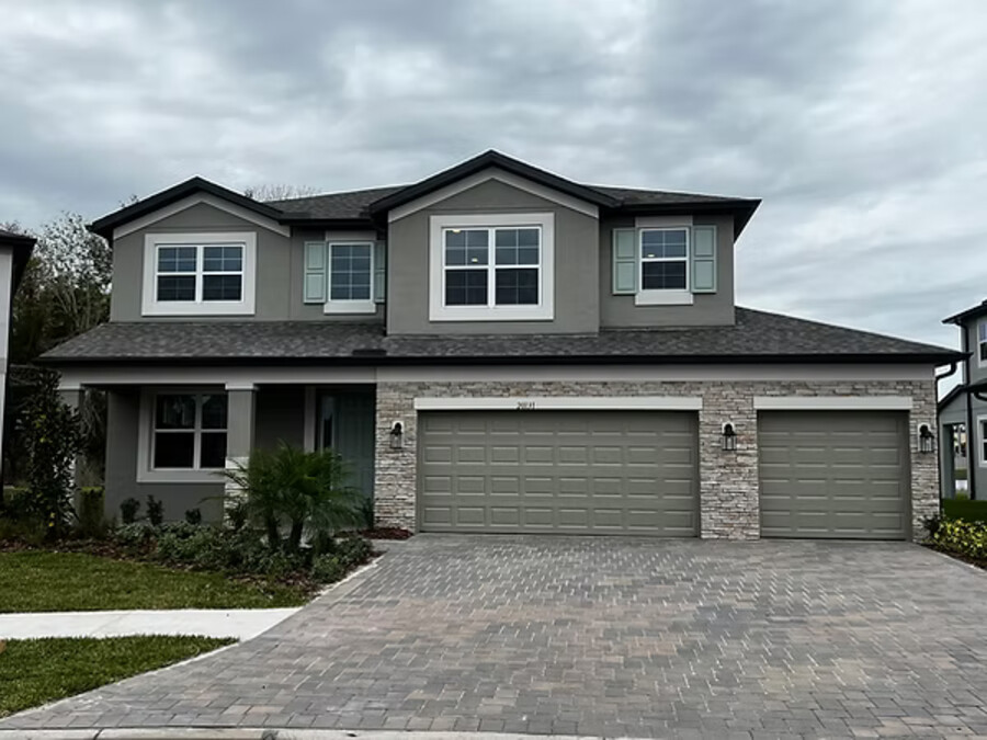 Two-story front elevation with white 6" seamless gutter and three-car garage