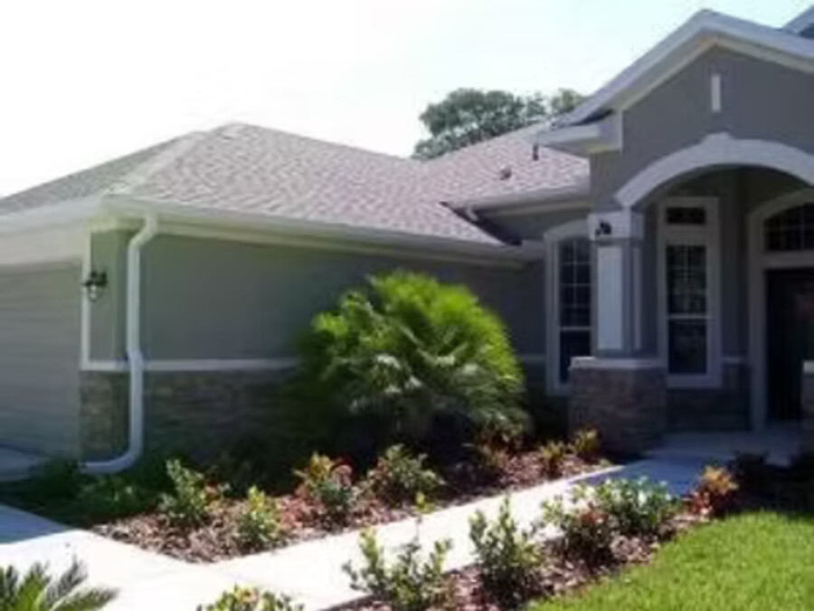 White downspout carried down the front elevation to a splash block