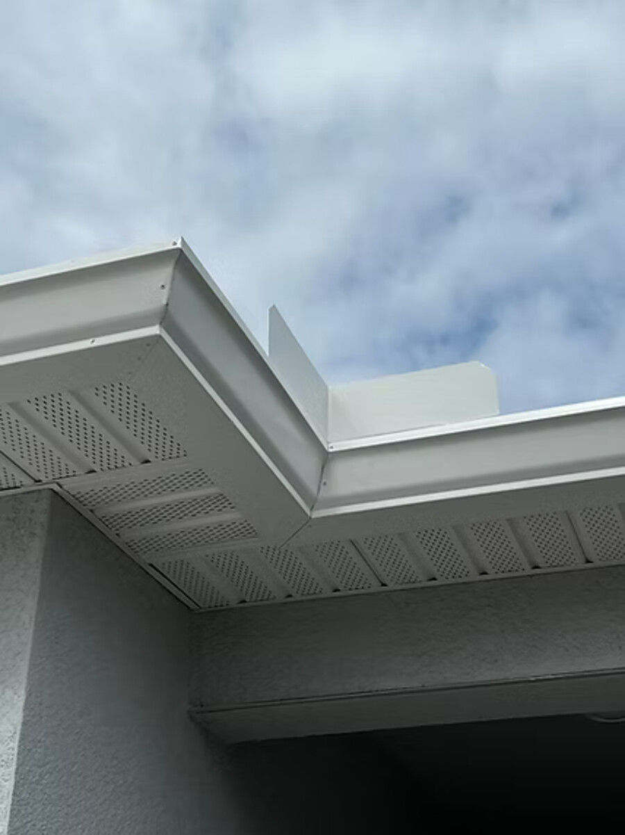 Hand-cut miter with five rivets on a white seamless gutter