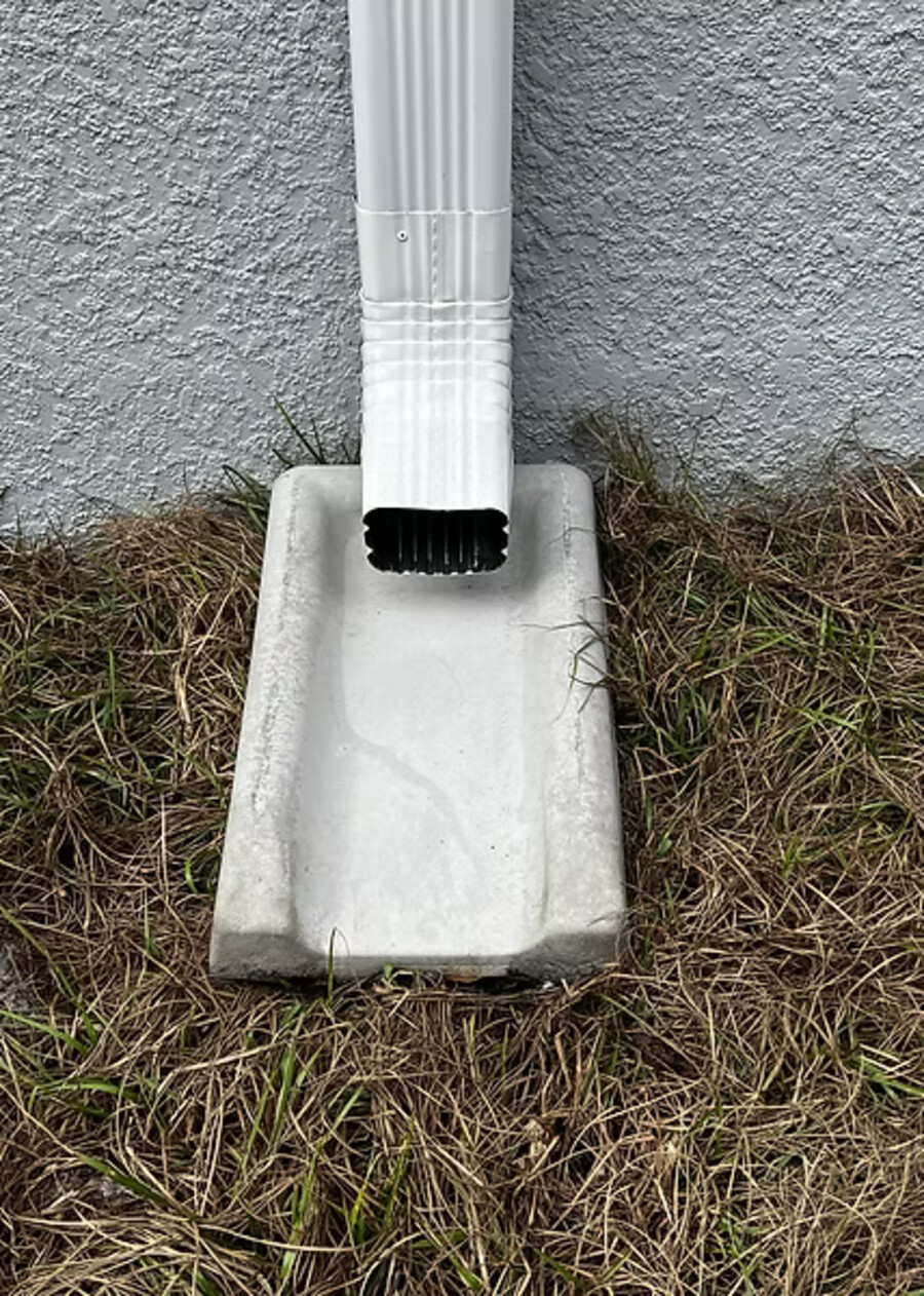 Concrete splash block at the base of a downspout