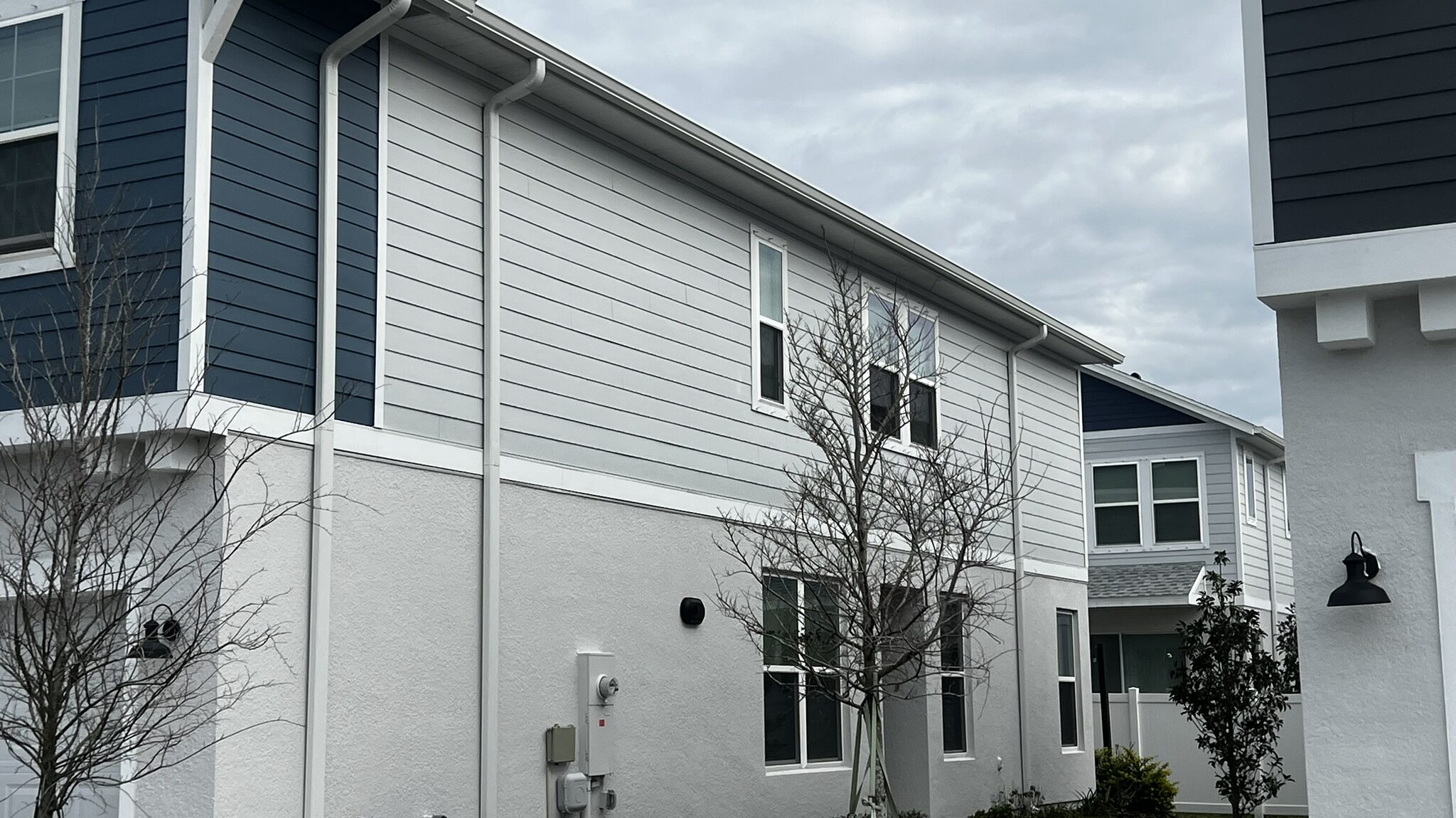 White seamless gutter and downspout carried down a Florida elevation